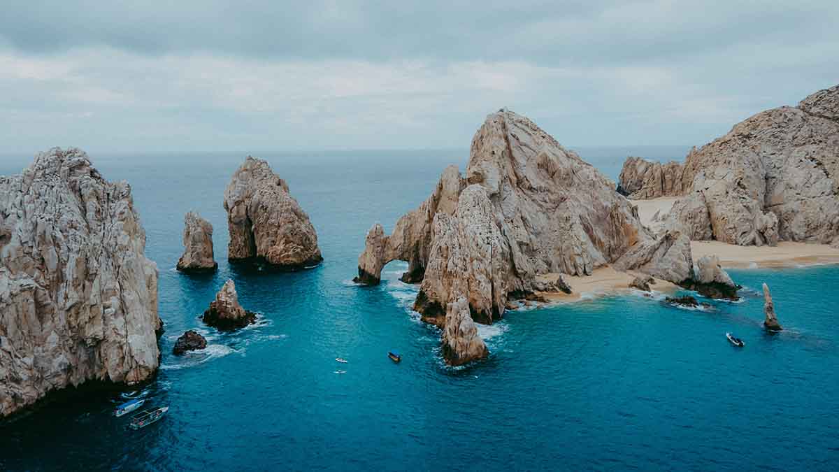 paddleboarders approaching The Arch in Cabo San Lucas